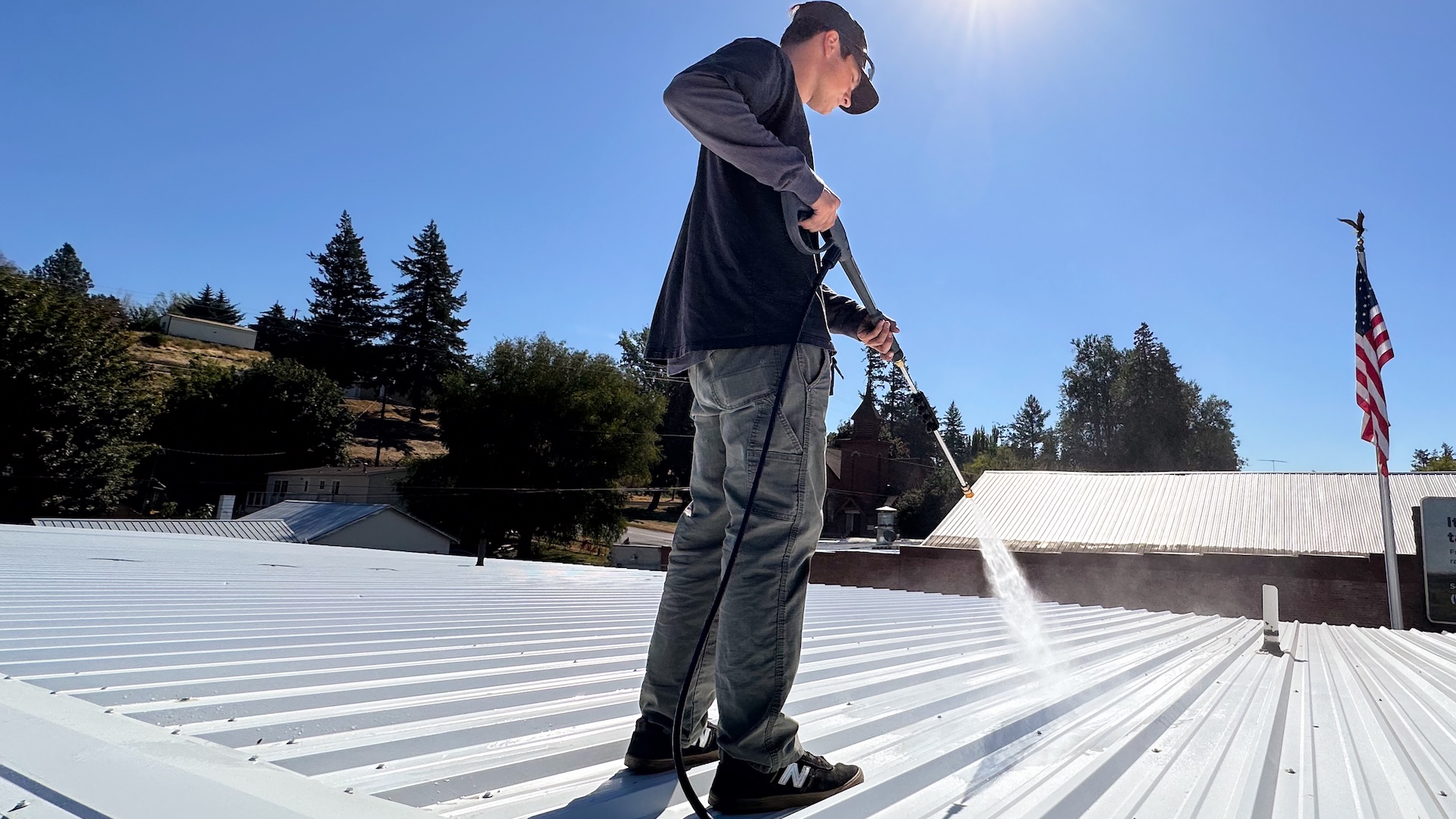 Commercial Roofer Power Washing And Preparing A Metal Roof For An Acrylic Coating